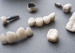 dental implants, crowns, and bridges lying on a flat surface 