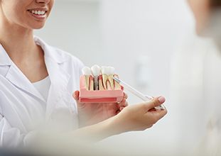 Dentist pointing to model of dental implant in Raleigh, NC