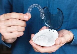 a person putting Invisalign aligners in a hard protective case
