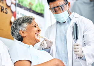 Smiling patient looking at reflection in mirror