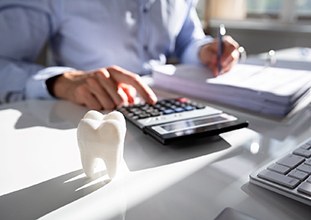 A cosmetic dentist in Raleigh calculating treatment cost