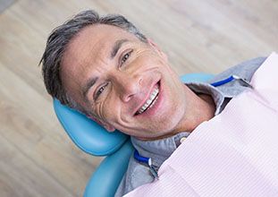 Male dental patient lying back and smiling
