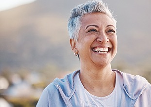 a woman smiling with dentures in Raleigh