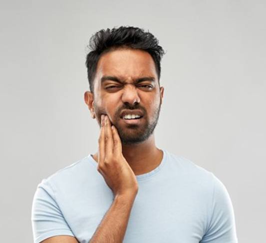 Pained man with toothache in Raleigh touches his cheek