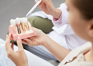 dentist showing a patient how dental implants work 