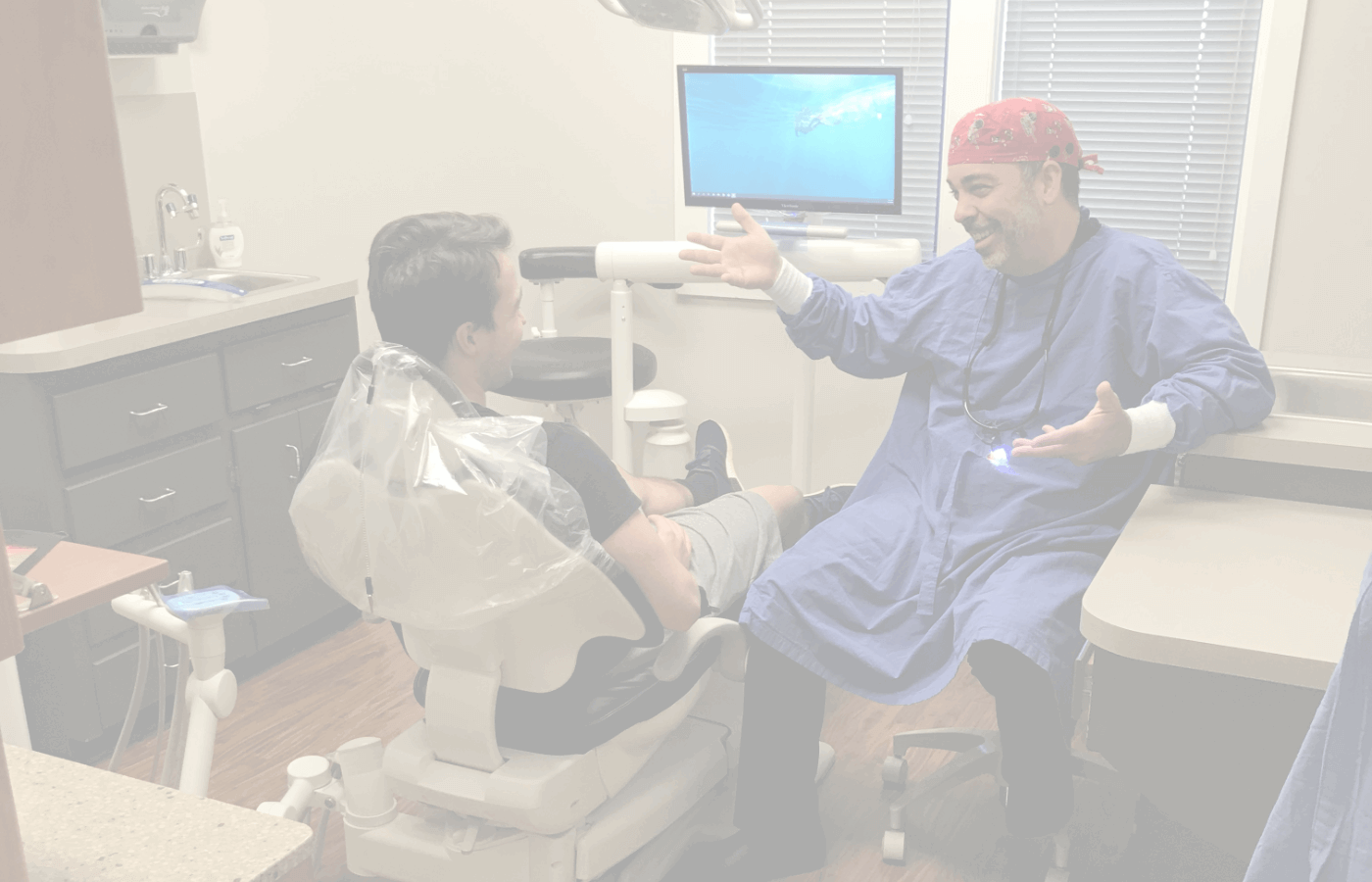 Raleigh laughing with a dental patient in the dental chair