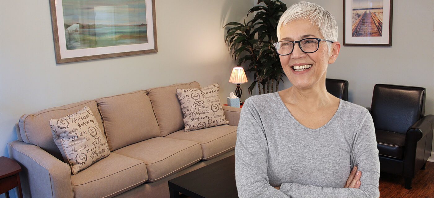 Older woman smiling with her arms crossed in Raleigh dental office waiting room