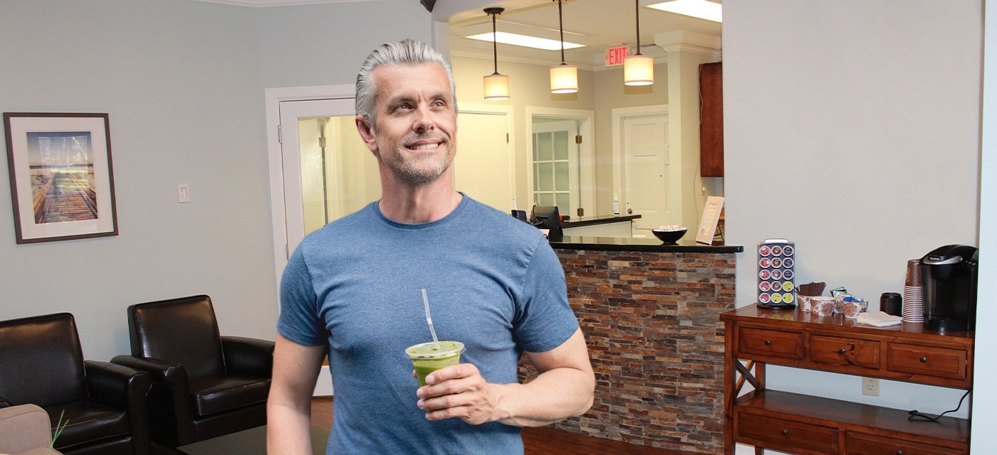 Man holding beverage cup in Raleigh dental office