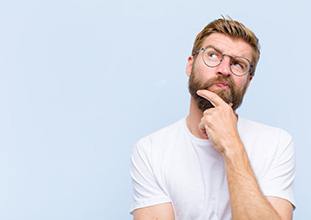 Man tapping his chin and looking to the side