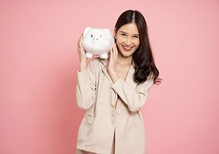 Woman holding a large piggy bank over her shoulder