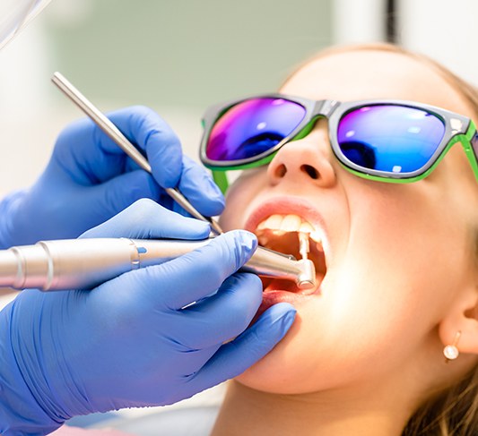 a young patient getting her teeth cleaned at the dental office