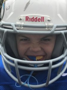 Young boy in football helmet with sportsguard