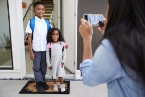 parent taking back-to-school pictures of their children