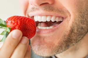 Closeup of man eating with dental implants in North Raleigh