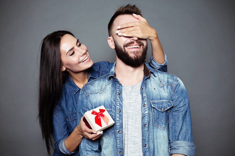 woman surprising partner with Valentine’s Day gift