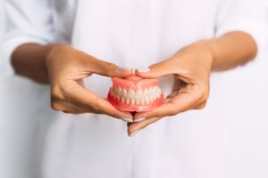 Patient holding their dentures.