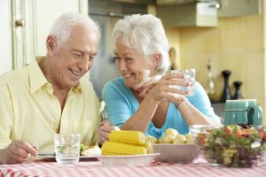 Patients smiling and eating dinner.