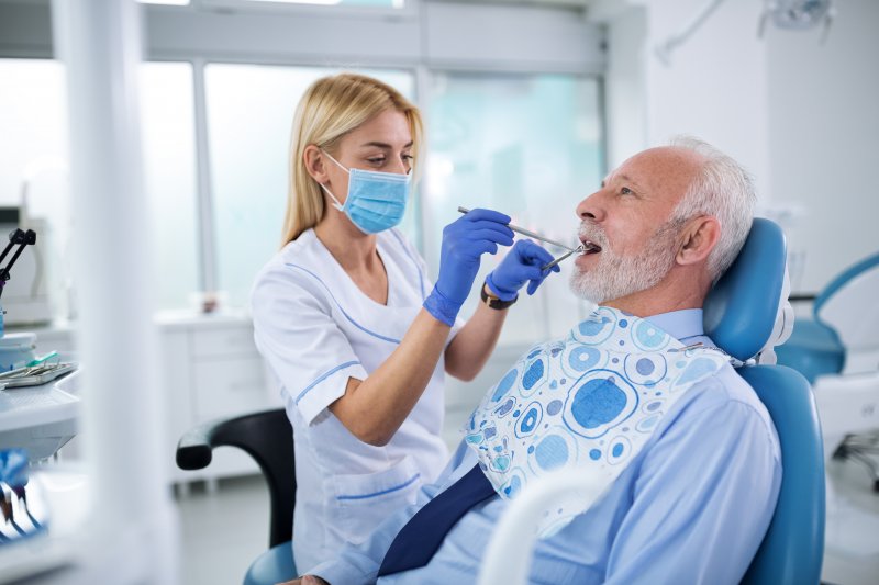 A cosmetic dentist in Raleigh treating an older patient