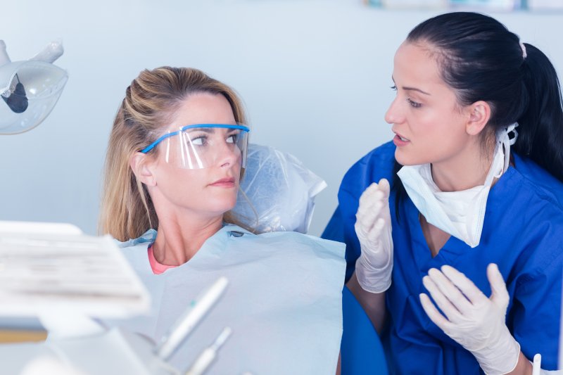 dentist explaining black line around dental crown to patient