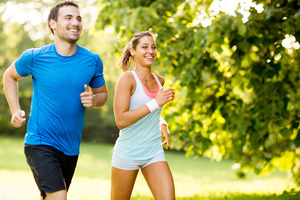 Man and woman jogging on a sunny path