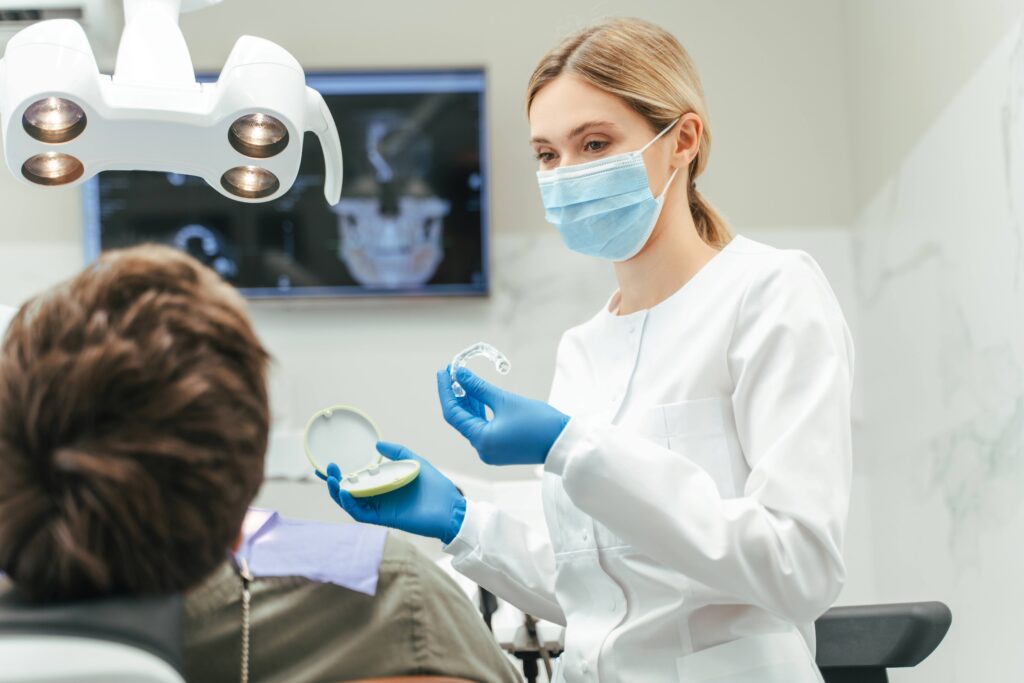 Dentist showing patient clear aligner in treatment room