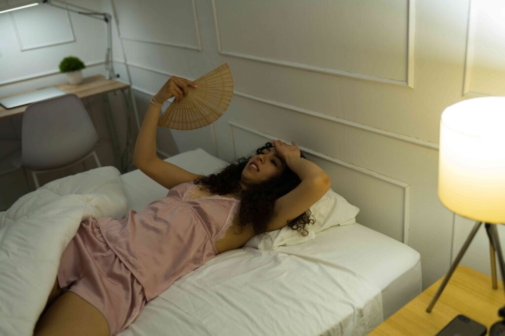 Woman trying to stay cool in bed